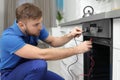 Professional serviceman repairing modern oven Royalty Free Stock Photo