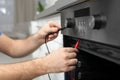 Professional serviceman repairing modern oven in kitchen Royalty Free Stock Photo