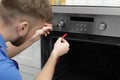 Professional serviceman repairing modern oven Royalty Free Stock Photo