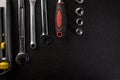 Professional set of hand tools. Utility knife, combination wrenches and a socket set with ratchet on a black background Royalty Free Stock Photo