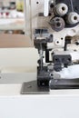 Professional sewing machine overlock in the workshop. Equipment for edging, hemming or stitching clothes in a tailor shop. Royalty Free Stock Photo