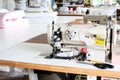 Professional sewing machine overlock in the workshop. Equipment for edging, hemming or stitching clothes in a tailor shop. Royalty Free Stock Photo