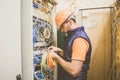 Professional signalman unravels the wires in the data center server room. The engineer works with computer switching equipment.