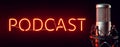 Professional silver microphone with orange illuminated PODCAST neon sign