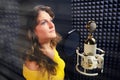 Professional singer in a yellow dress, close-up. Woman singing into the microphone at the recording studio. Recording vocals in a Royalty Free Stock Photo