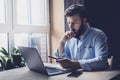 Professional sitting in office in front of laptop. Home-based student getting distant education. Serious man working on desktop