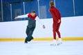 Professional skater, man training girl, learning figure skating activity on ice rink arena. Sport lessons with coach