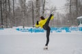 Professional skater on an outdoor ice rink. A woman on knees is preparing a solo program for the competition.