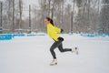 Professional skater on an outdoor ice rink. A woman on knees is preparing a solo program for the competition.