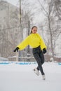 Professional skater on an outdoor ice rink. A woman on knees is preparing a solo program for the competition.