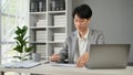 A professional Asian businessman focuses on reading business documents at his desk Royalty Free Stock Photo