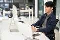 Professional Asian male developer working at his modern office desk, using computer and laptop Royalty Free Stock Photo