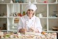 Professional smiling confectioner wrapping a box with cookies