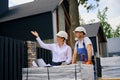 Professional specialist inspecting cottage facade in presence of housebuilder Royalty Free Stock Photo