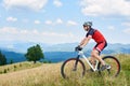 Professional sportsman cyclist in sportswear and helmet riding a bike in high grass Royalty Free Stock Photo