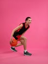 Professional sportswoman playing basketball on pink background