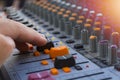 Professional stage sound mixer closeup at sound engineer hand using audio mix slider