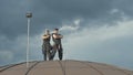 Professional steeplejacks on the roof against a cloudy sky