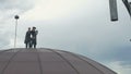 Professional steeplejacks at the roof against the sky