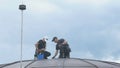 Professional steeplejacks are working at the roof of the business center