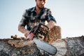 Professional strong lumberman sawing a big tee on sawmill Royalty Free Stock Photo