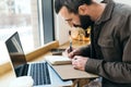 Professional, stylish man working remotely in a modern cafe