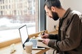 Professional, stylish man working remotely in a modern cafe