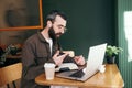 Professional, stylish man working remotely in a modern cafe