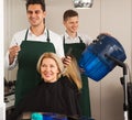 Professional stylist cutting hair of elderly blonde in hairdresser salon Royalty Free Stock Photo