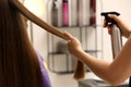Professional stylist spraying water onto client`s hair in salon Royalty Free Stock Photo