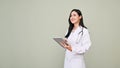 Professional Asian female doctor holding a tablet, looking away from camera Royalty Free Stock Photo