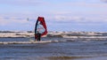 Professional surfer in the wind preparing the wind in the sea to the ocean. Windsurfer catches the wave in a storm. Concept of: Sp