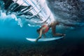 Professional surfer woman with surfboard dive underwater with barrel ocean wave.