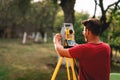 Professional surveyor engineer measuring and working with total station