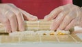 Professional sushi chef preparing roll at commercial kitchen, close-up. Royalty Free Stock Photo