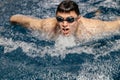 Professional swimmer competes in an indoor swimming pool race. Concept of competitions and motivation for sports Royalty Free Stock Photo