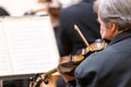 Professional symphonic string orchestra performing on stage and playing a classical music concert, violinist in a Royalty Free Stock Photo