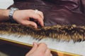 Professional tailor, designer repairing fur coat at atelier, studio. Fashion and tailoring concept. Royalty Free Stock Photo