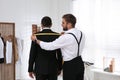 Professional tailor measuring client`s shoulder width in atelier Royalty Free Stock Photo