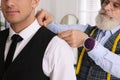 Professional tailor working with client in atelier, closeup Royalty Free Stock Photo