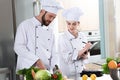 Professional team of cooks checking recipe during Royalty Free Stock Photo