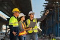 A Professional team of engineers, architects, inspecting and working outside on expressway construction site with laptop at road Royalty Free Stock Photo