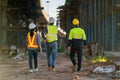 A Professional team of engineers, architects walking, inspecting and working on a highway construction site with a laptop at a