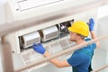 Professional technician maintaining modern air conditioner