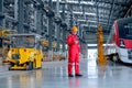 Professional technician worker stand near factory truck and hold and look to mobile phone in electrical or metro train factory. Royalty Free Stock Photo