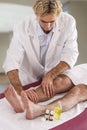 Professional therapist giving relaxing reflexology Thai foot massage to a woman in spa Royalty Free Stock Photo