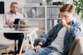 Professional therapist and teenage boy ignoring him during appointed meeting Royalty Free Stock Photo