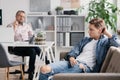 Professional therapist and teenage boy ignoring him during appointed meeting