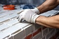 hands of the tiler are laying yellow ceramic tile on the wall. ai generated