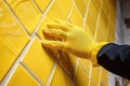 hands of the tiler are laying yellow ceramic tile on the wall. ai generated